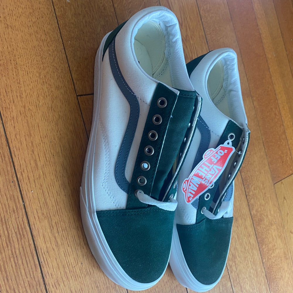 White, dark green and gray Vans sneakers.